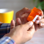 Sick man holding a medicine pill container and thinking about drug addiction treatment
